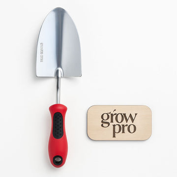 Grow Pro stainless steel gardening trowel with red ergonomic handle, displayed on a white background next to engraved wooden Grow Pro logo plaque.”