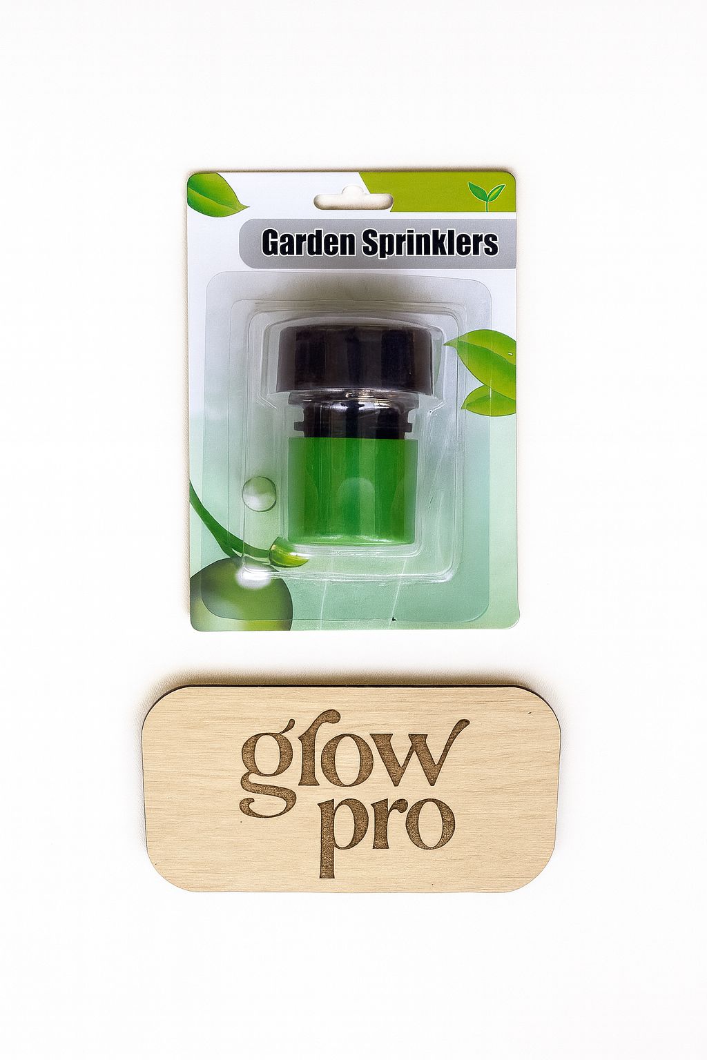 “Product photograph of a Garden Sprinkler nozzle in retail packaging with a black and green nozzle, placed above a wooden Grow Pro logo plaque, on a white background, optimized for e-commerce with centered alignment and bright lighting.”}